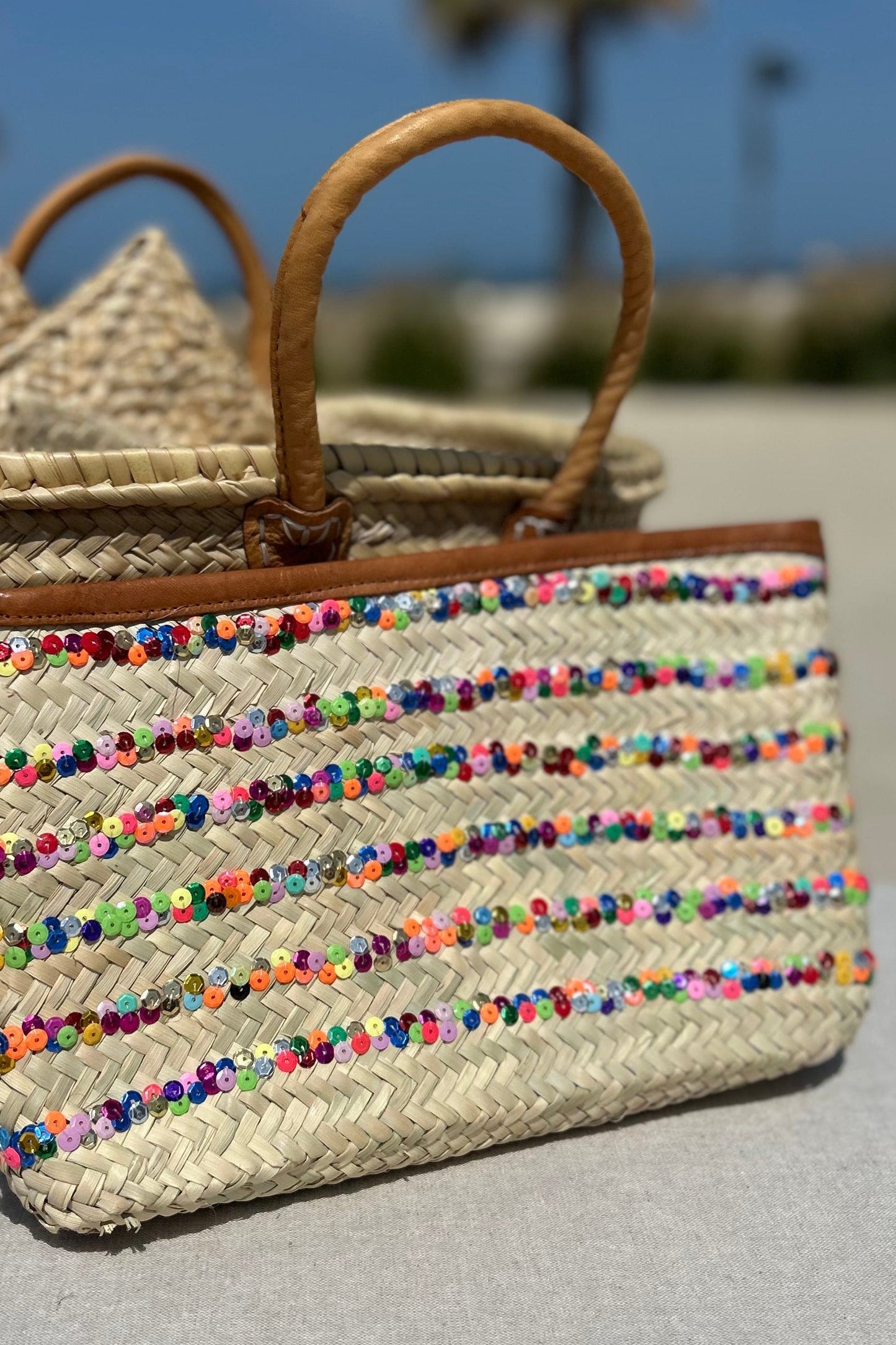 Hand made Morroccan woven straw bag with colorful sequin stripe with a tan leather trim and zipper to close