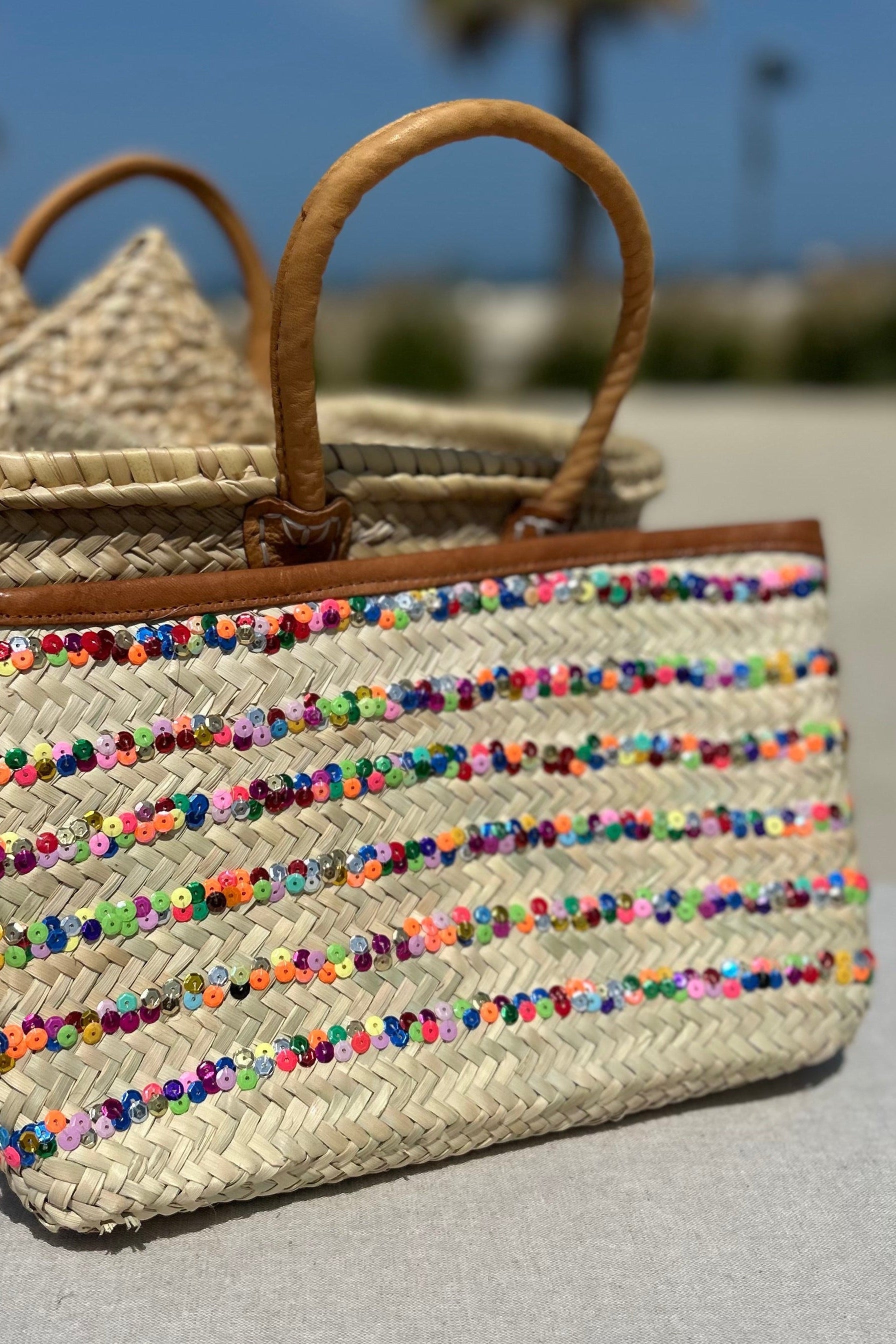 Hand made Morroccan woven straw bag with colorful  sequin stripe with a tan leather trim and zipper to close