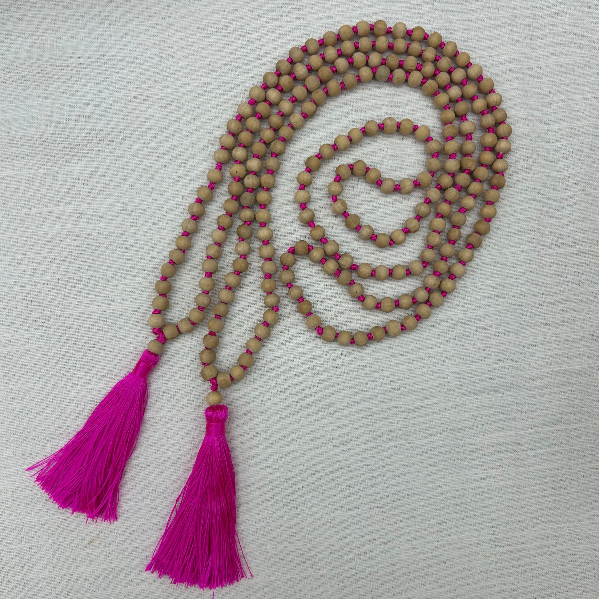 Necklace with wooden beads and pink tassels 